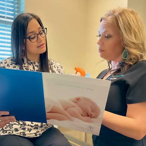 Patient and nurse going over prenatal handbook.