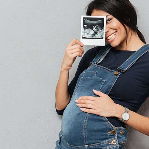 woman holding ultrasound picture